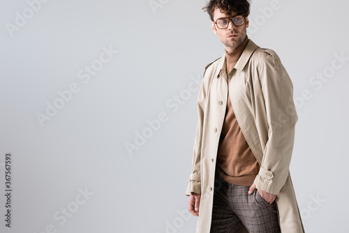 Tableau sur toile handsome, fashionable man holding hand in pocket and looking away isolated on gr