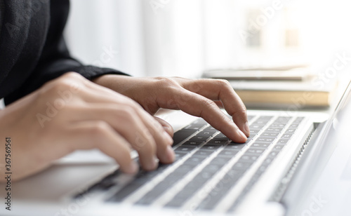 Girl typing on a laptop keyboard.