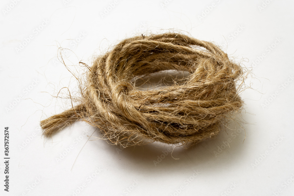 Jute twine isolated on white background. hank of twine close-up. jute rope for packing and decoration. skein of natural jute twine macroshot. Linen rough threads. raw material for industrial Jute twine isolated on white background. hank of twine close-up. jute rope for packing and decoration. skein of natural jute twine macroshot. Linen rough threads. raw material for industrial