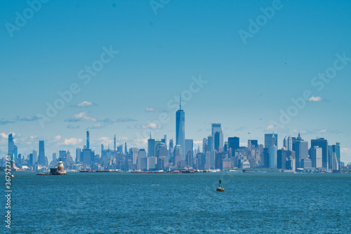 Statue of Liberty and lighthouse in front of Manhattan