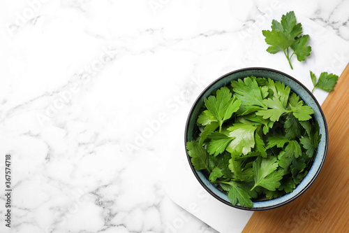 Fresh green parsley on white marble table  top view. Space for text