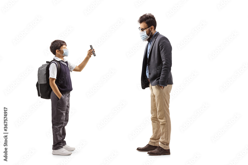 choolboy with a face mask showing a mobile phone to a bearded man