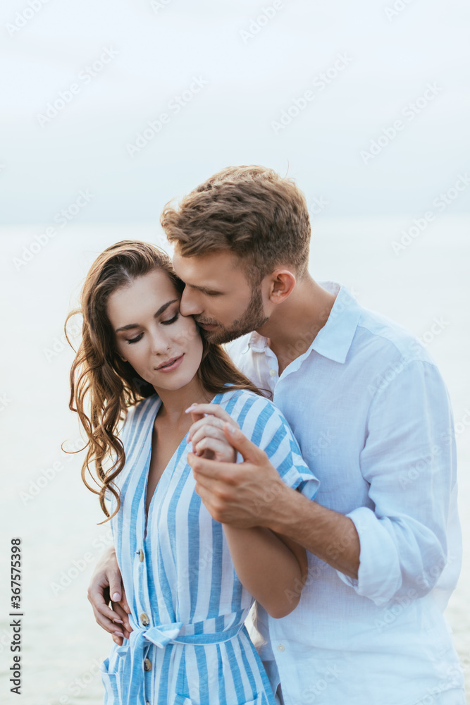 bearded man kissing and holding hands with attractive girl bearded man kissing and holding hands with attractive girl