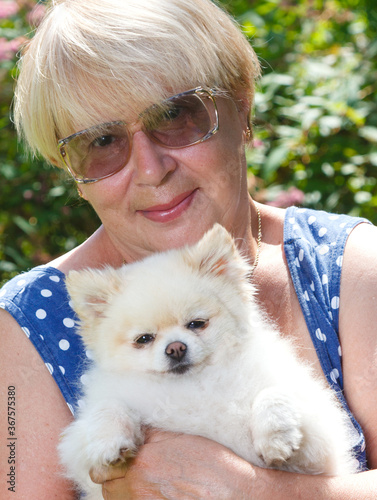 an elderly woman with a Pomeranian dog