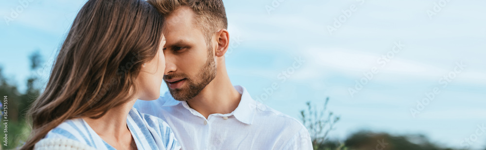 Fototapeta premium panoramic crop of bearded man looking at girlfriend outside
