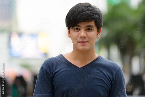 Portrait of young handsome Asian man in the city outdoors © Ranta Images