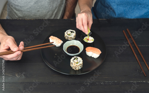 Two people eating sushi. Copy space. Food concept.