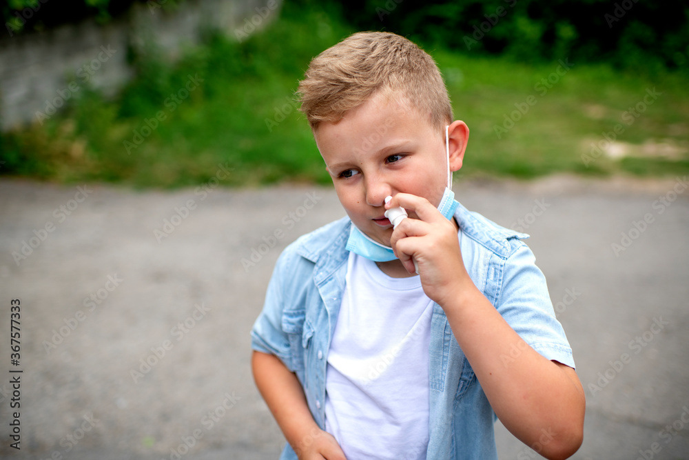 Portrait of boy with nasal spray. Boy wearing a face mask down. Portrait of boy with nasal spray. Boy wearing a face mask down.