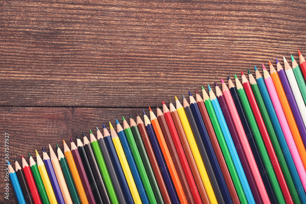 Fototapeta premium Colored pencils on brown wooden table