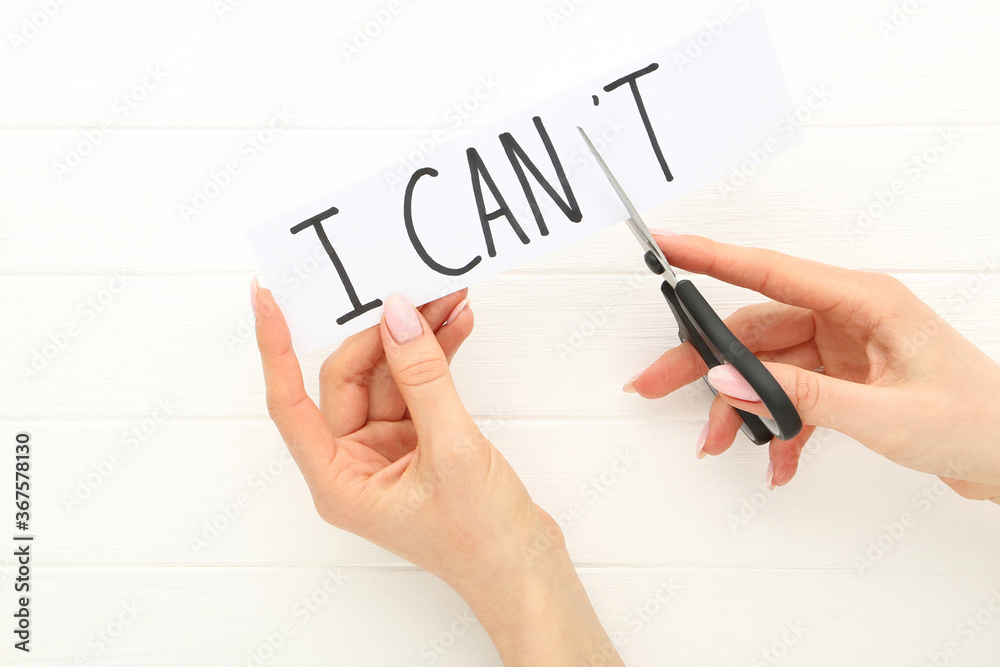 Female hands using scissors for cutting word I Can't Female hands using scissors for cutting word I Can't