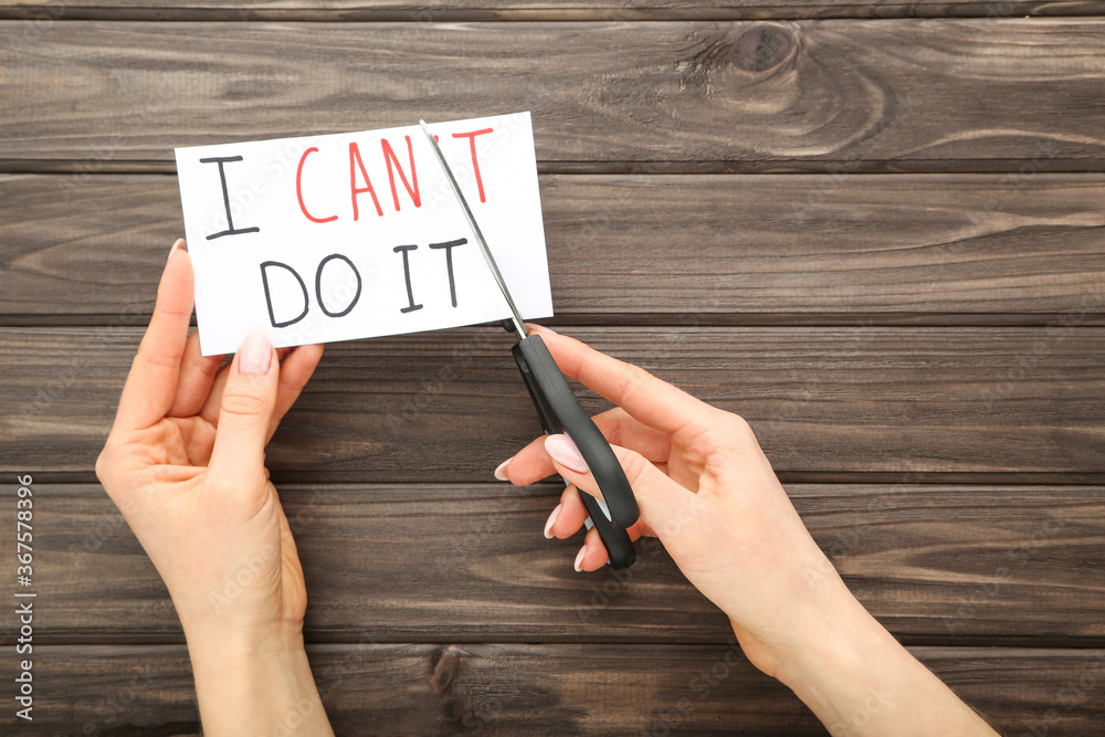 Female hands using scissors for cutting word I Can't Do It Female hands using scissors for cutting word I Can't Do It