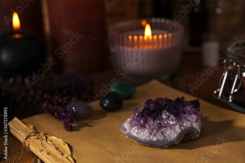 Composition with healing amethyst gemstone on table