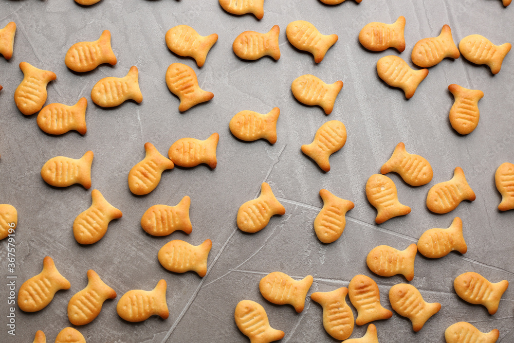 Delicious goldfish crackers on grey table, flat lay Delicious goldfish crackers on grey table, flat lay