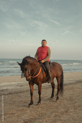 Man riding horse at the beach.