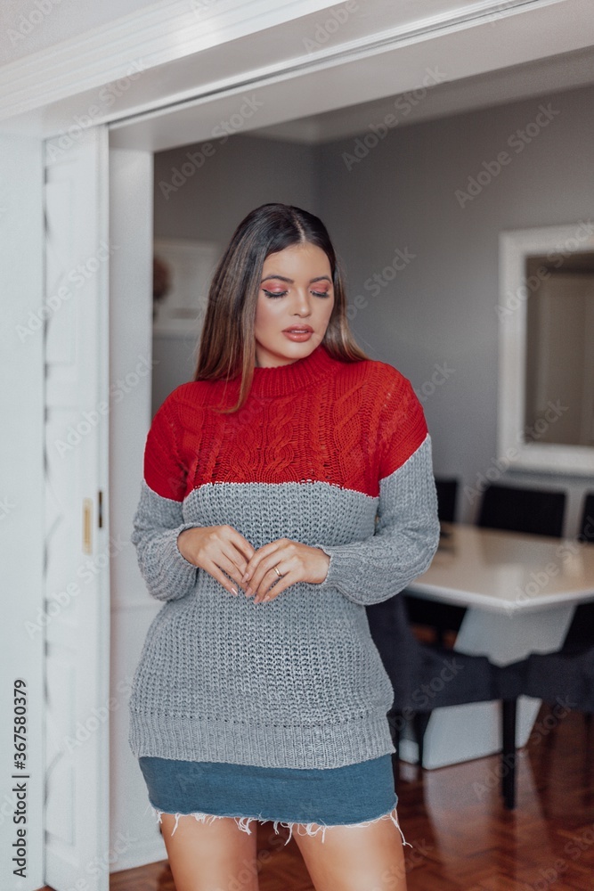 Beautiful model posing for photos in the living room. Wearing denim skirt and gray blouse. Beautiful model posing for photos in the living room. Wearing denim skirt and gray blouse.