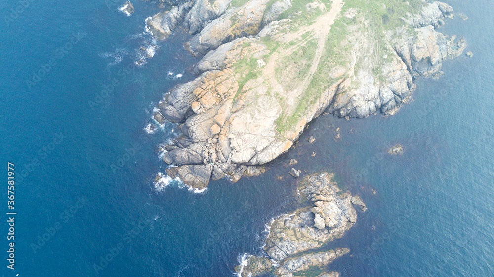 Aerial view of Cliffs and colorful landscape near the sea. reefs reminiscent of the continents of the world. The weather is foggy 