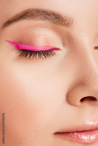close up view of beautiful woman with pink eyeliner