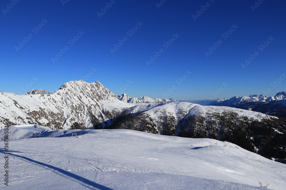 Panorama of Gaital alps with the highest mountain Eggenkofel on the left. Blue sky with ideal snow condition means perfect ski slope and enjoying the view. Ski resort Obertilliach