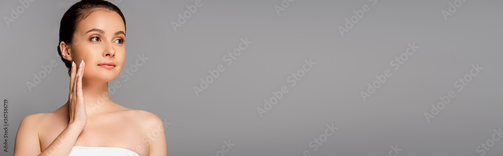 beautiful woman with perfect skin touching face and looking away isolated on grey, panoramic shot beautiful woman with perfect skin touching face and looking away isolated on grey, panoramic shot