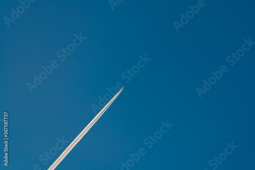 A long trail of jet plane on blue sky