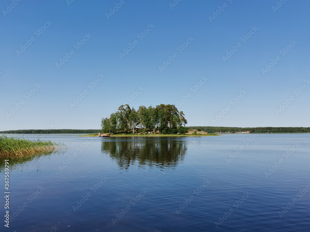 A stone island with pines and birches surrounded by water. Vyborg, park Monrepo, Russia