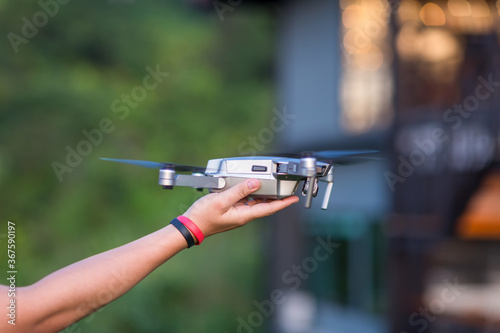 The Drone and photographer human hand. drone copter flying with digital camera near hand. 