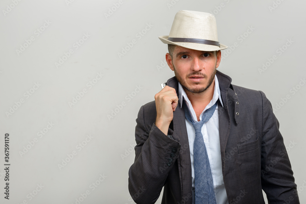 Portrait of handsome bearded Hispanic businessman wearing hat