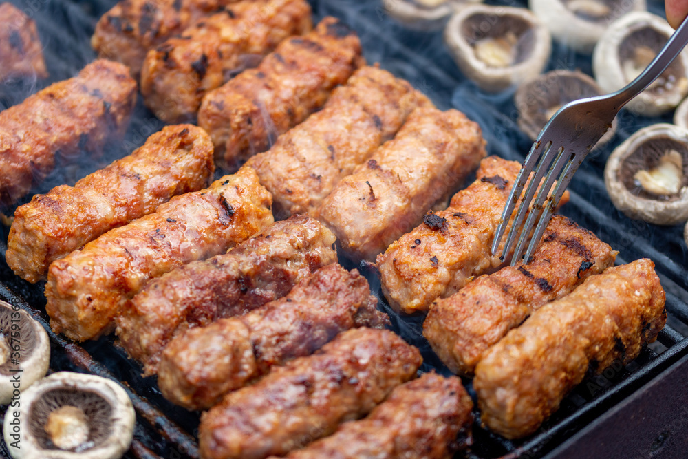 assorted barbecue of meat rolls or mici and champignon
mushrooms 