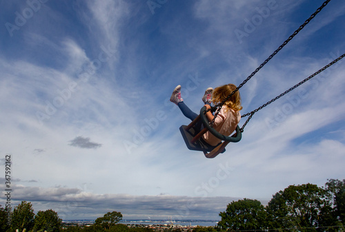 Little girl swinging high