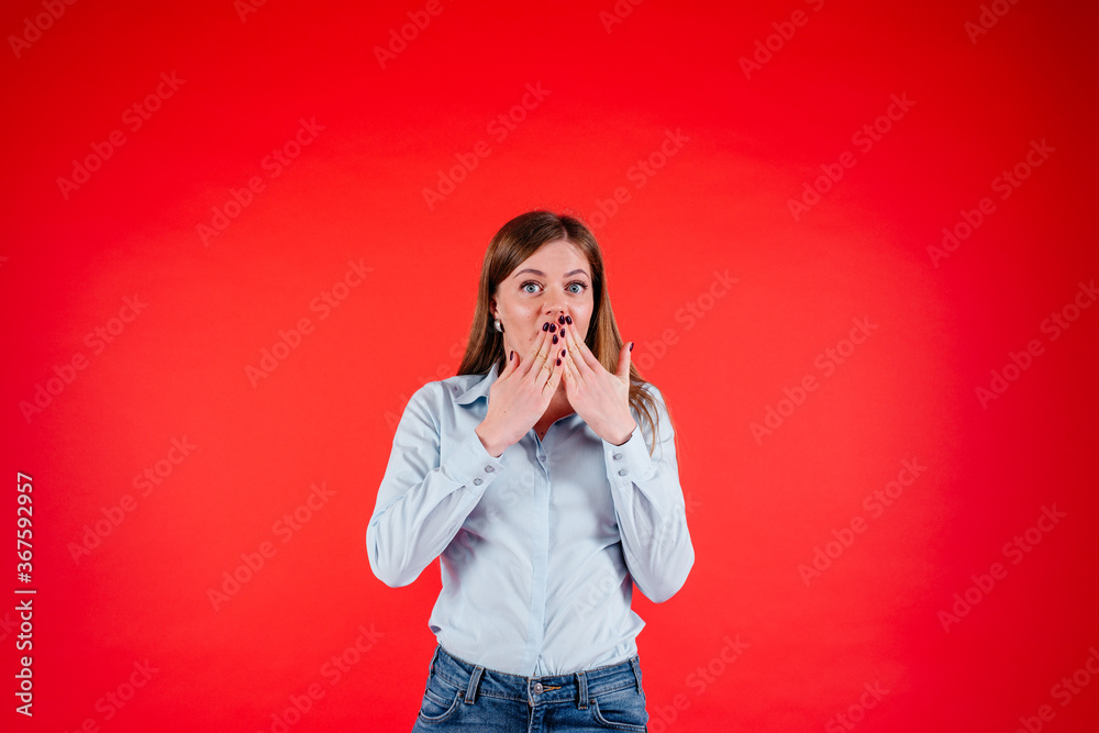 Surprised young woman holds her hands near the mouth, wondering in excitement Surprised young woman holds her hands near the mouth, wondering in excitement