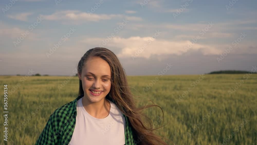Beautiful teenage girl with long hair in the park. A young girl runs through a wheat field. Happy, free young girl in green wheat. Hair develops in the wind. Beautiful teenage girl with long hair in the park. A young girl runs through a wheat field. Happy, free young girl in green wheat. Hair develops in the wind.