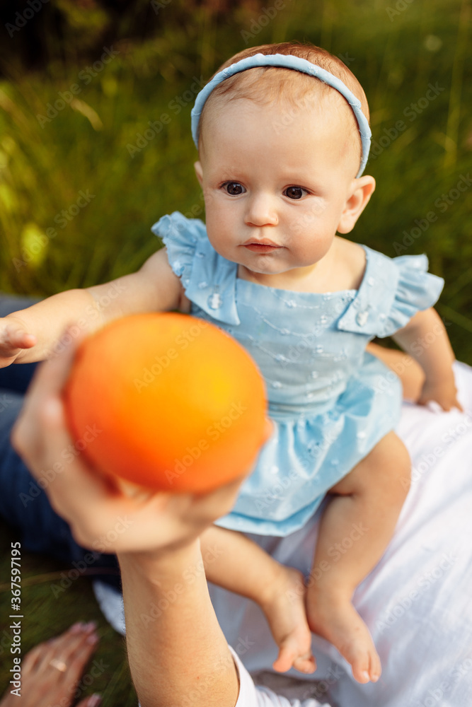 Small baby girl in blue dress with family having a picnic Small baby girl in blue dress with family having a picnic