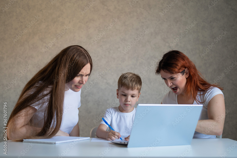 Two disgruntled women swear at their son doing homework. Female tutors swear at the boy. A lesbian couple is engaged in home schooling with a child. Distance education in quarantine. Two disgruntled women swear at their son doing homework. Female tutors swear at the boy. A lesbian couple is engaged in home schooling with a child. Distance education in quarantine.