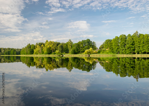 summer morning landscape on the lake, beautiful clouds and wonderful reflections in the lake mirror, summer morning by the water