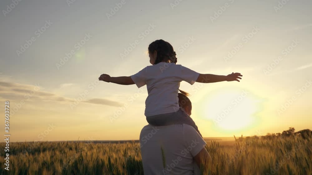 A happy boy on the shoulders of his father plays Aviator, the family spends time playing in the sunset sky. A dream of flight, travel, vacation. Happy family A happy boy on the shoulders of his father plays Aviator, the family spends time playing in the sunset sky. A dream of flight, travel, vacation. Happy family