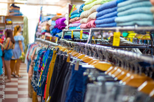 multicolored women clothing hangs on a hanger in a clothing store. Choice of knitwear. summer discounts. © Natalia