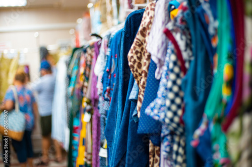 women home dresses hang on a hanger in a clothing store. Choice of knitwear. Buying and selling, summer discounts.