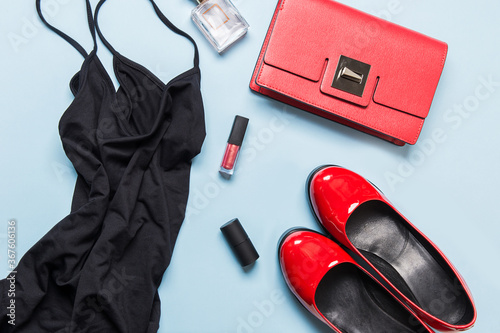 Elegant little black dress and classic red accessories for special date. Flat lay. View from above. Party preparations
