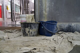 buckets are placed under the drops of water of a leaking pipe