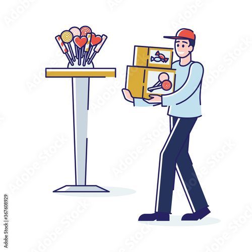 Candy shop worker bring box with fresh lollipops for store showcase. Confectionary candy shop