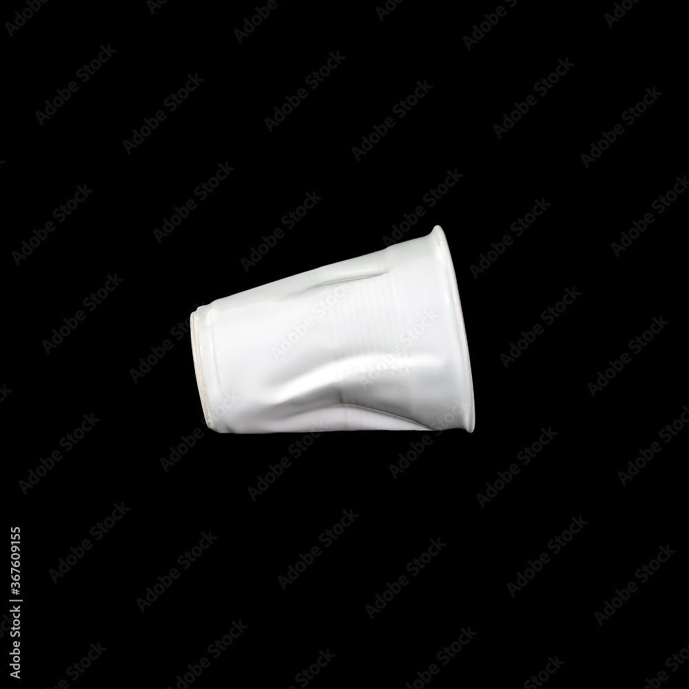 Crumpled white disposable paper plastic cup isolated on black Crumpled white disposable paper plastic cup isolated on black