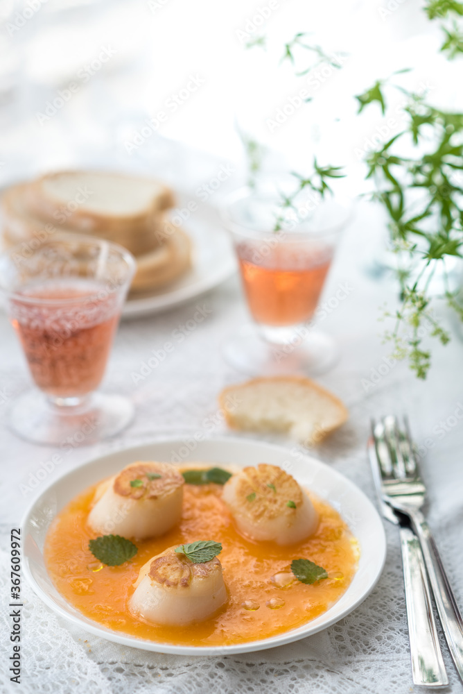 Pan Seared Sea Scallops with Orange Tomato Sauce. Glass of Rose Wine Pan Seared Sea Scallops with Orange Tomato Sauce. Glass of Rose Wine