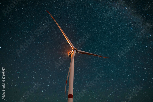 Wind turbine in the night at the stars background. Environment and renewable energy