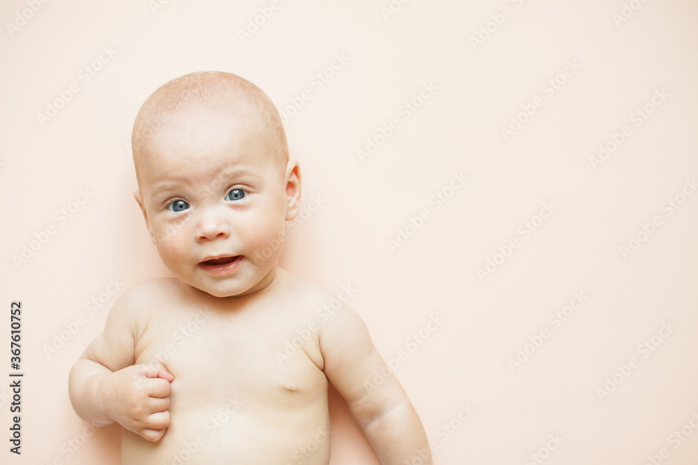 Little cute baby lies on a light pink background. Free space for text. Little cute baby lies on a light pink background. Free space for text.