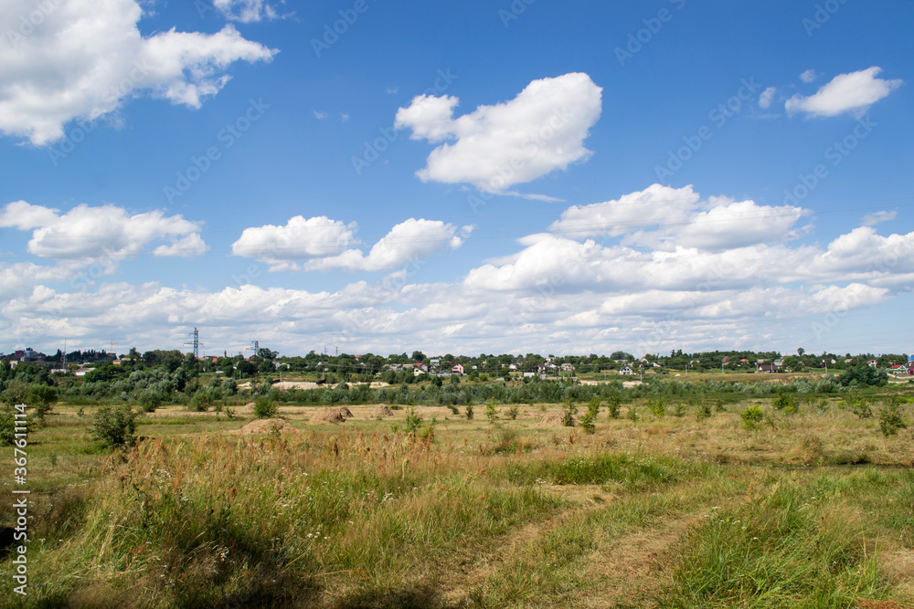 Countryside landscape with blue sky and white clouds.