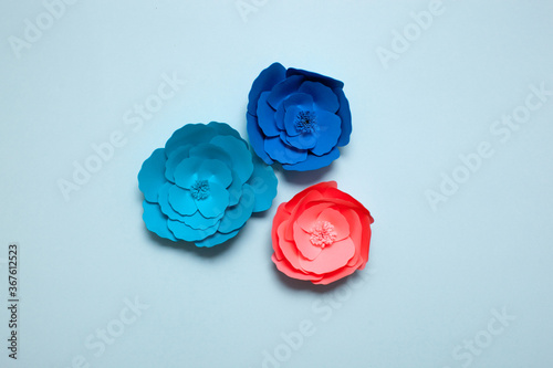 Set of handmade paper art and cutout flower on blue background. photo