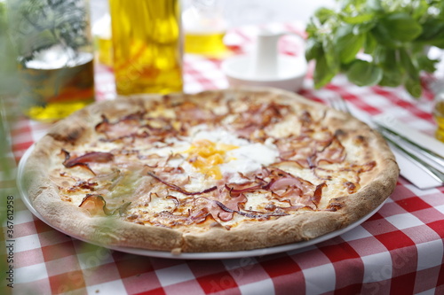 Pizza with bacon, onion, and egg. Italian cuisine. Traditional Italian pizza. Suggestion to serve a dish. Food background.