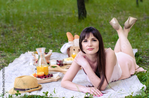 Smiling young woman having summer picnic in park outdoors © anniebrusnika
