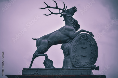 Fragment of a gate with a sculpture of a deer and military paraphernalia