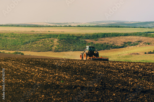 Photo of tractor cultivating a land, preparation for new year.
